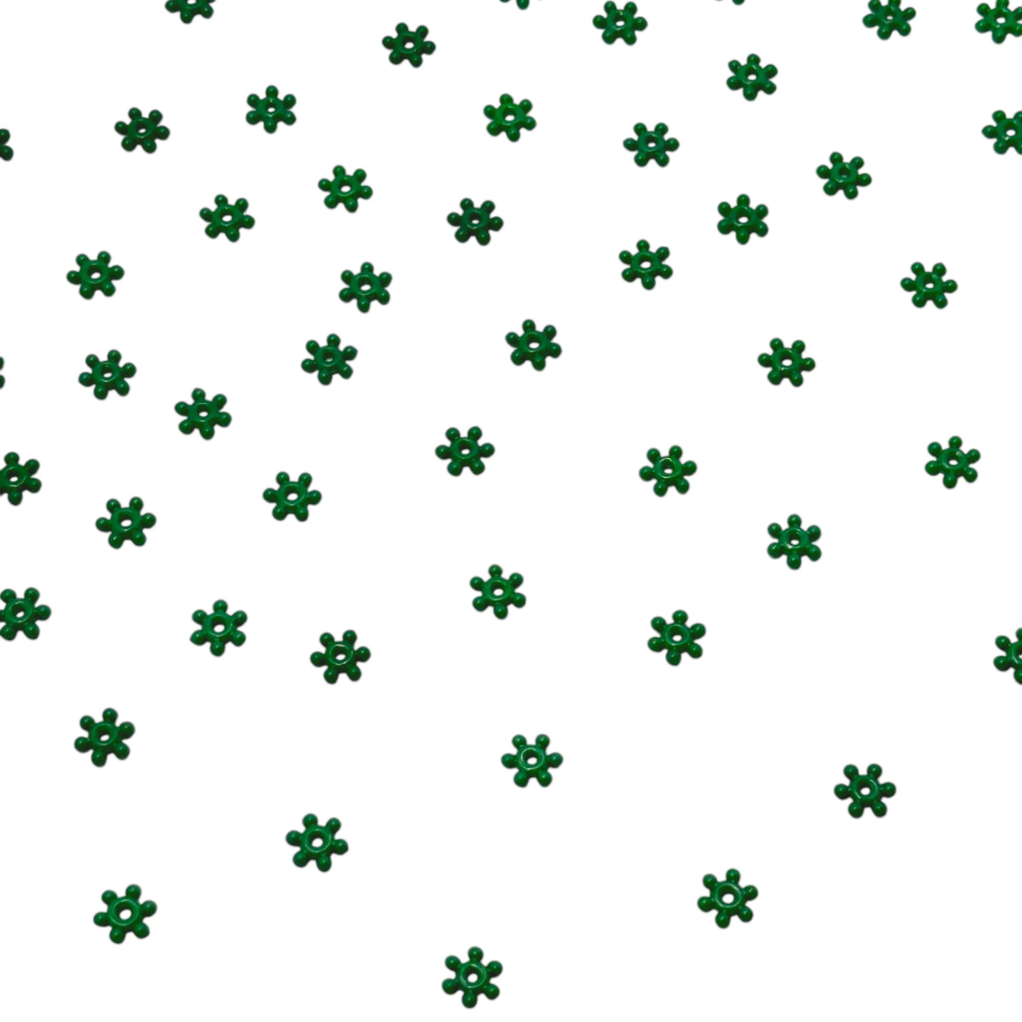 Emerald green acrylic flower craft beads scattered on white background