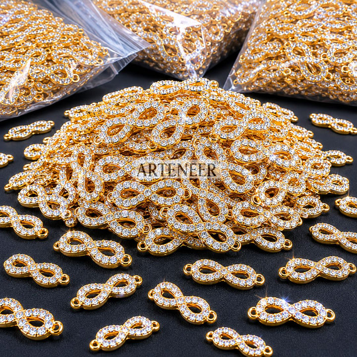 Gold and silver jewelry connectors with 'Arieteener' branding on a black surface.
