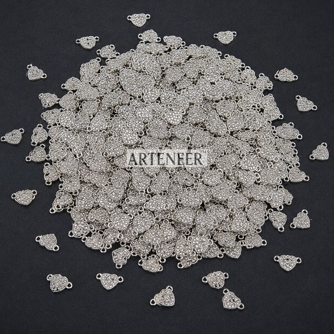 Pile of silver jewelry charms with 'Arteneer' branding on a black background