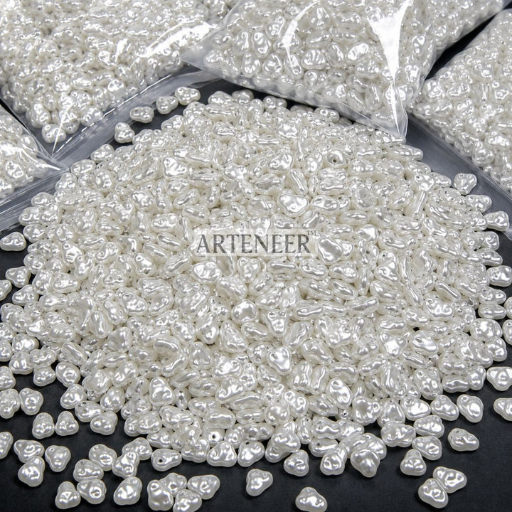 White pearl-like beads with 'Arteneer' branding on a black surface